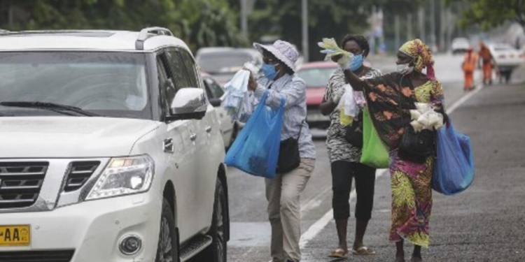 Vendors attempt to sell face masks to a motorist in Libreville on April 9, 2020. (Photo by STEEVE JORDAN / AFP)